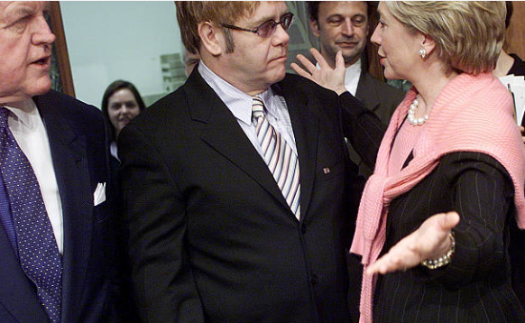 Sir Elton John talking with Senators Hillary Rodham Clinton and Ted Kennedy before testifying at the U.S. Senate Committee on Health, Education, Labor and Pensions in Washington, D.C., April 11, 2002