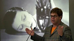 Elton John in front of Man Ray's artwork