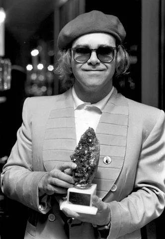 21st September 1977: British pop star Elton John holding the Melody Maker trophy for Best Female Singer, which he collected for Kiki Dee in her absence.