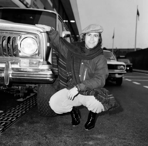 Elton John pictured next to an American Jeep at London Airport. February 1979