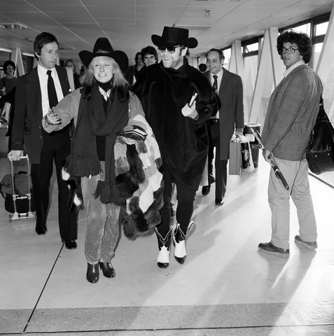 Elton John and Zandra Rhodes at Heathrow. 11th January 1981.