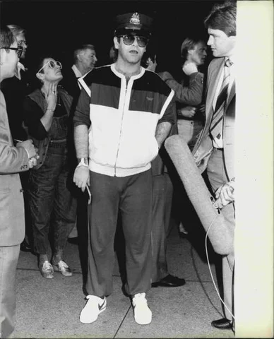 Elton John arrives at Sydney Airport weaving a New York policemans hat. He is hear & appear as a quest on the Michael Parkinson Show