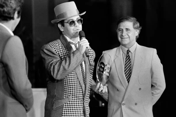 Photo taken on December 17, 1984 in Paris shows English singer Elton John (L) and French coach of the national team Michel Hidalgo during the awarding ceremony "Les trophées du sport" on French TV Antenne 2.