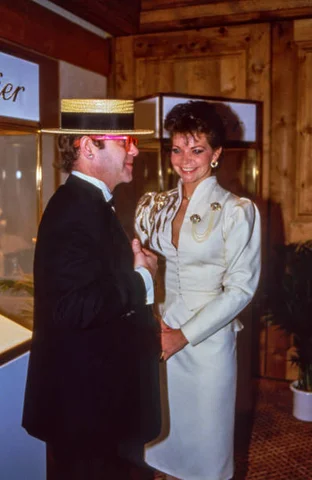 Elton John at a Cartier Evening in Gstaad Elton John and his wife Renate Blauel visit a Cartier exhibition on January 3, 1985, in Gstaad, Switzerland.