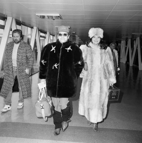 Elton John and wife Renate leaving Heathrow Airport for Washington where he is to play tennis. 11th February 1986.