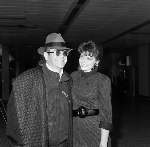 Elton John with his wife Renate arriving from Los Angeles at London Airport. 17th October 1986.