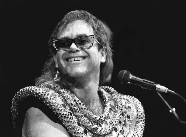Sir Elton Hercules John, born Reginald Dwight, is shown performing on stage during a live concert appearance on August 29, 1986 in Hartford, Connecticut