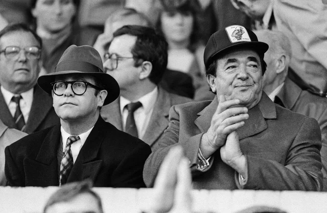 Elton John and Robert Maxwell watching the Oxford United v Watford football match. Final score 1-1. League Division One. Elton John had announced days before that he was selling his 90 per cent holding in Watford FC. 21st November 1987.