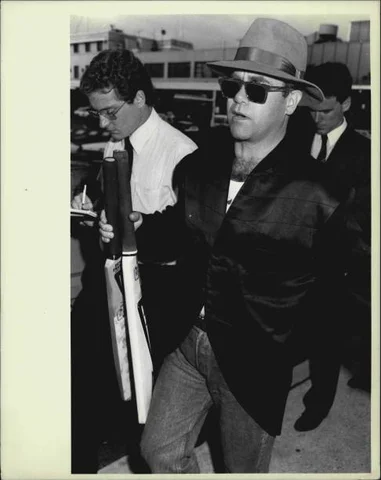 Rock star Elton John, pictured leaving Sydney Airport today with his two circus *****. April 03, 19874