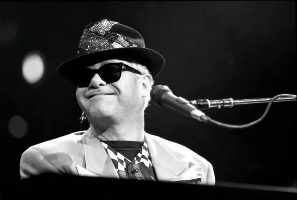 Sir Elton Hercules John, born Reginald Dwight, is shown performing on stage during a live concert appearance on July 28, 1989 in Hartford, Connecticut.
