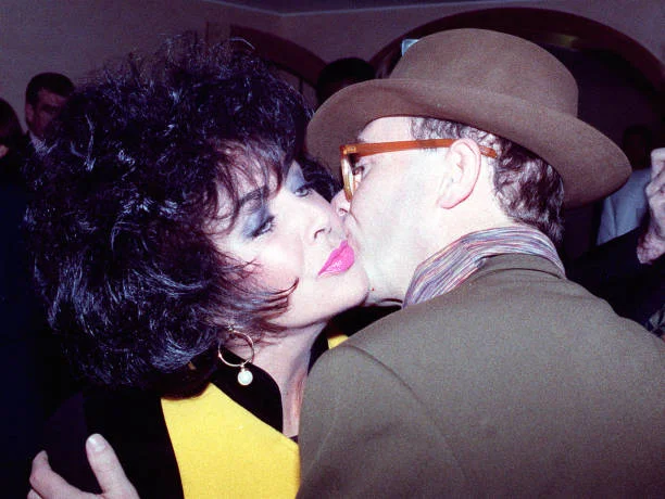 Liz Taylor and Elton John greet each other. Liz Taylor and Elton John greet each other at the charity re-opening of the rebfurbished Mirabelle restaurant in London's Mayfair