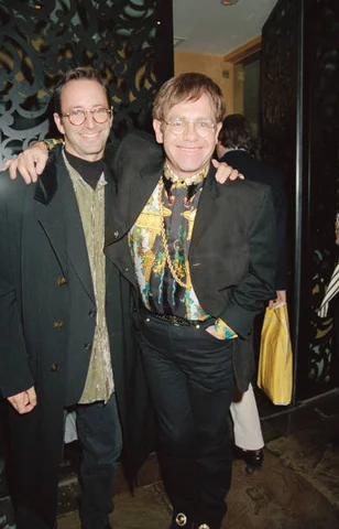 Photographer Herb Ritts (1952 - 2002, left) with singer and pianist Elton John at Daphne's restaurant, 15th December 1993