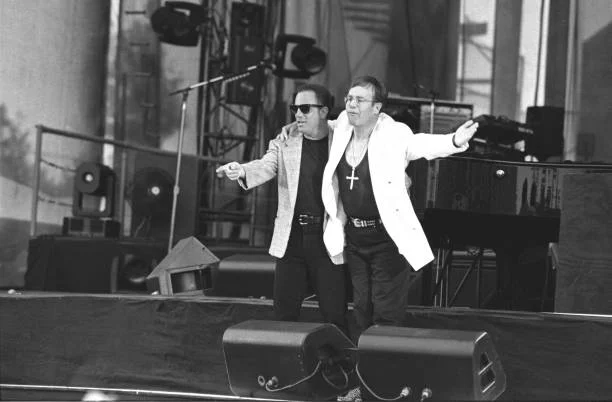 Billy Joel And Elton John Performing Together In Concert Musicians Billy Joel and Elton are shown performing on stage together during a very special "live" concert appearance on July 17, 1994