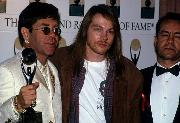 Elton John, Axl Rose, & Bernie Taupin Elton John, Axl Rose of Guns N' Roses, and Bernie Taupin at Rock and Roll Hall of Fame Waldorf Astoria, New York, January 19, 1994