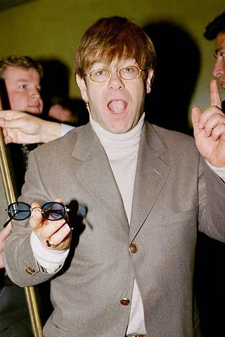 MARCH 31: Elton John displays a pair of his Limited Edition glasses during a Vanity Fair magazine party. Sales will go to benefit the Elton John Aids Foundation.