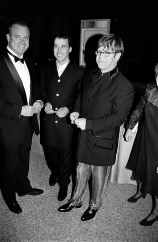 1995 Costume Institute Gala at the Met (L-R) Guest, David Furnish, and Elton John attend an event at the Metropolitan Museum of Art in New York City on December 4, 199
