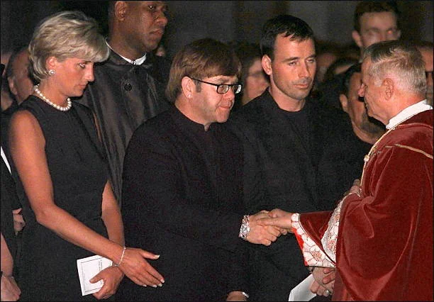 Archpriest Magio (R) shakes hands with British rock star Elton John standing next to Princess Diana (L) during the requiem mass for Italian fashion designer Gianni Versace at the Duomoin Milan 22 July 1997. Versace was gunned down in Miami Beach 15 July