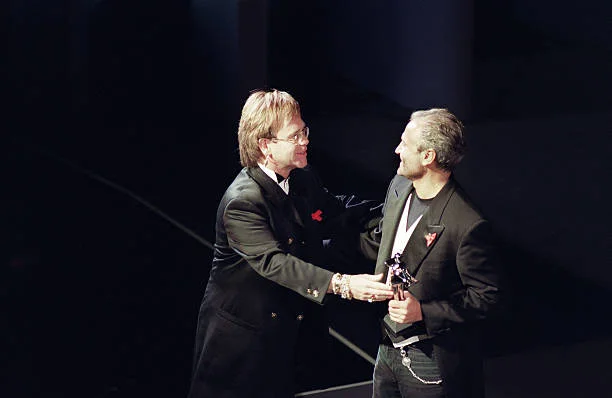 British singer Elton John (L) presents Italian designer Gianni Versace (R) with the 1992 Council of Fashion Designers of America International Award at the council's annual awards ceremony, 01 February 1993.