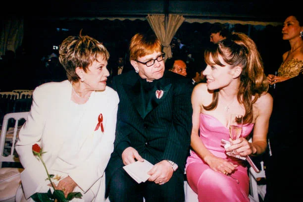 Jeanne Moreau and Elton John at a party. Jeanne Moreau, Liz Hurley, and Elton John at the amfAR Gala on May 21, 1998, in Mougins, France.